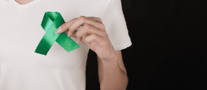 Man holding green liver cancer awareness ribbon.