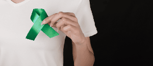 Man holding green liver cancer awareness ribbon.
