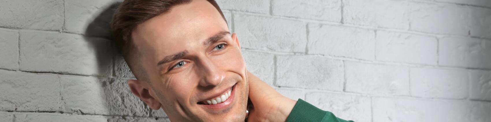 Happy man smiling with a full head of hair after a hair transplant.