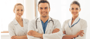 Three intimate area plastic surgery doctors standing and smiling.
