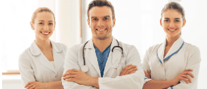 Three intimate area plastic surgery doctors standing and smiling.