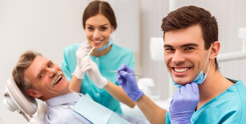 Uomo con grandi denti che sorride in un ambiente di campagna
