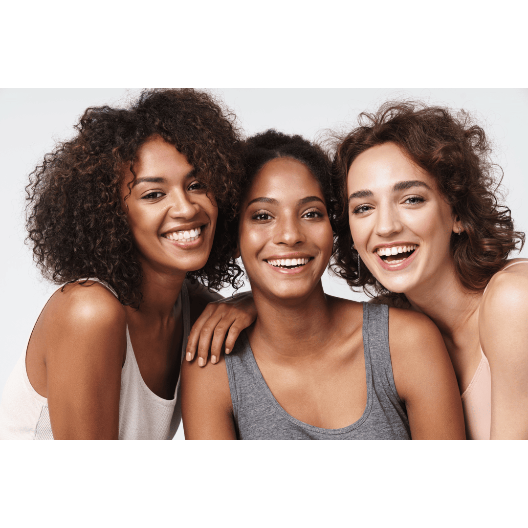 Three women smiling together and hugging
