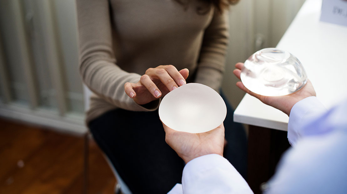 Die Patientin berät sich mit dem Arzt darüber, welche Art von Brustimplantaten verwendet werden soll.