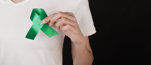 Man holding green liver cancer awareness ribbon.
