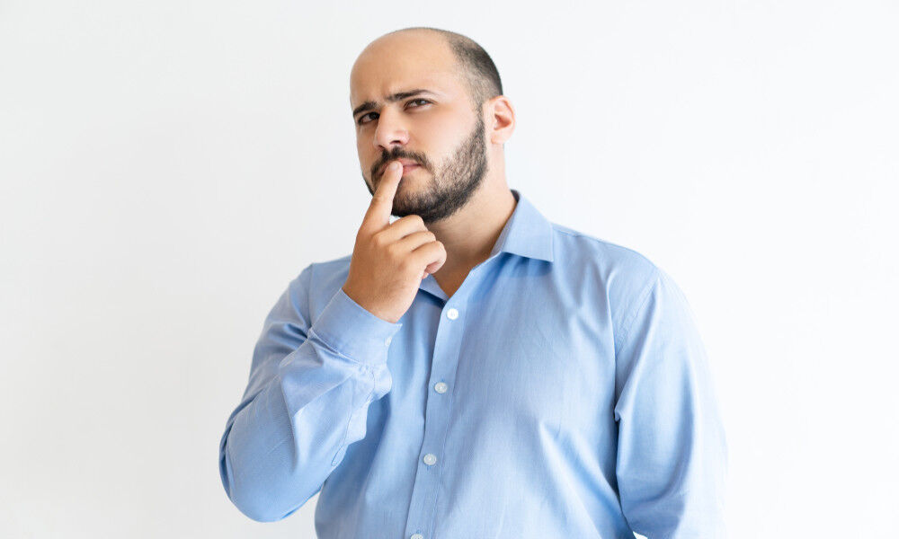 Balding man thinking about a hair transplant
