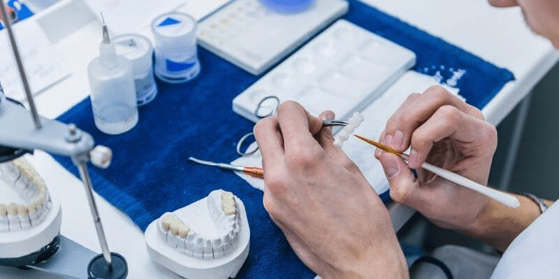 A lab technician making some crowns.