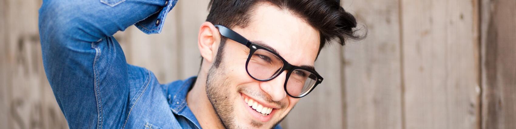 Man with thick head of hair smiling after undergoing a sapphire FUE hair transplant.