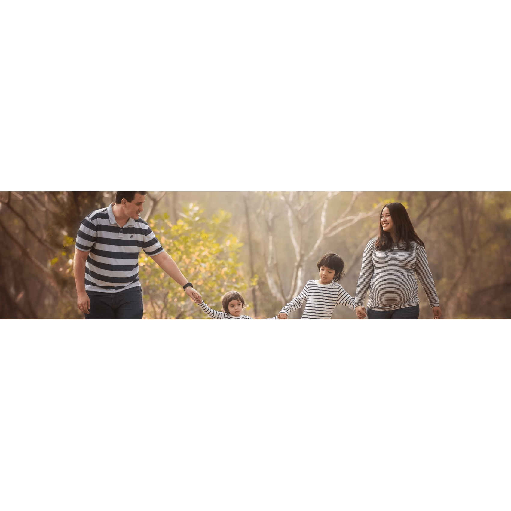 Happy family walking in the woods holding hands after successful IVF.