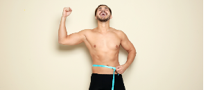 Happy man measuring waist after weight loss surgery.