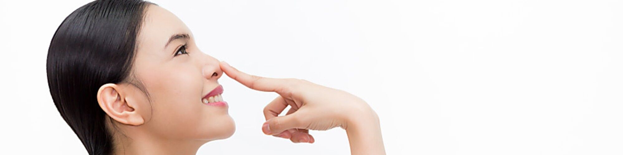 Happy woman touching her nose after rhinoplasty surgery.