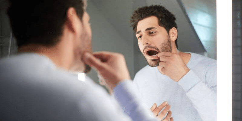 Checking for black teeth in the mirror
