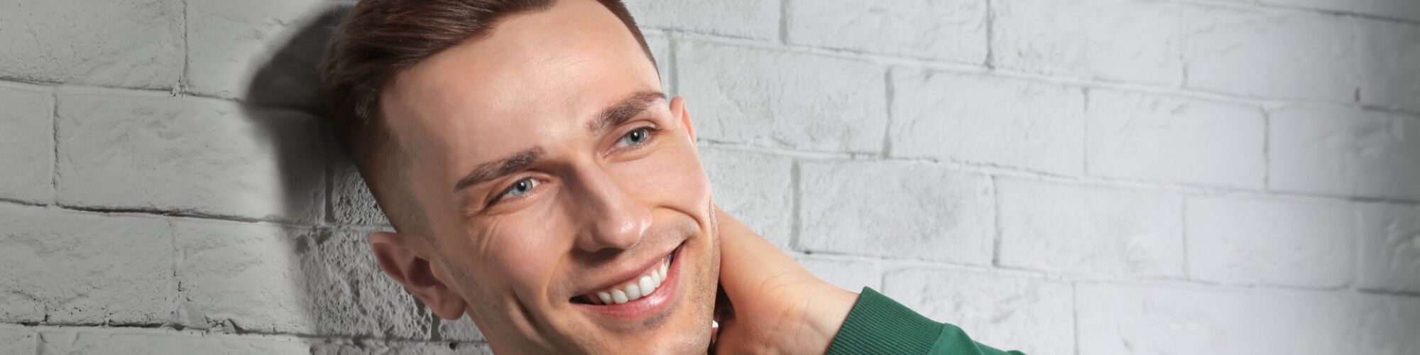 Happy man smiling with a full head of hair after a hair transplant.