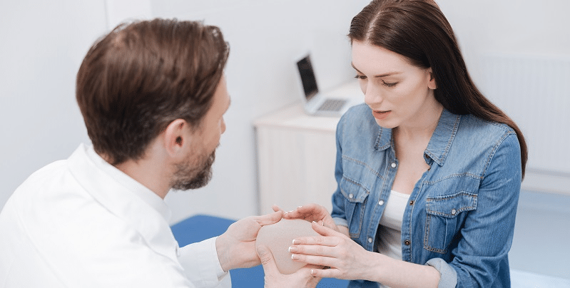 Healthy woman looking towards the camera and smiling with a white background.
