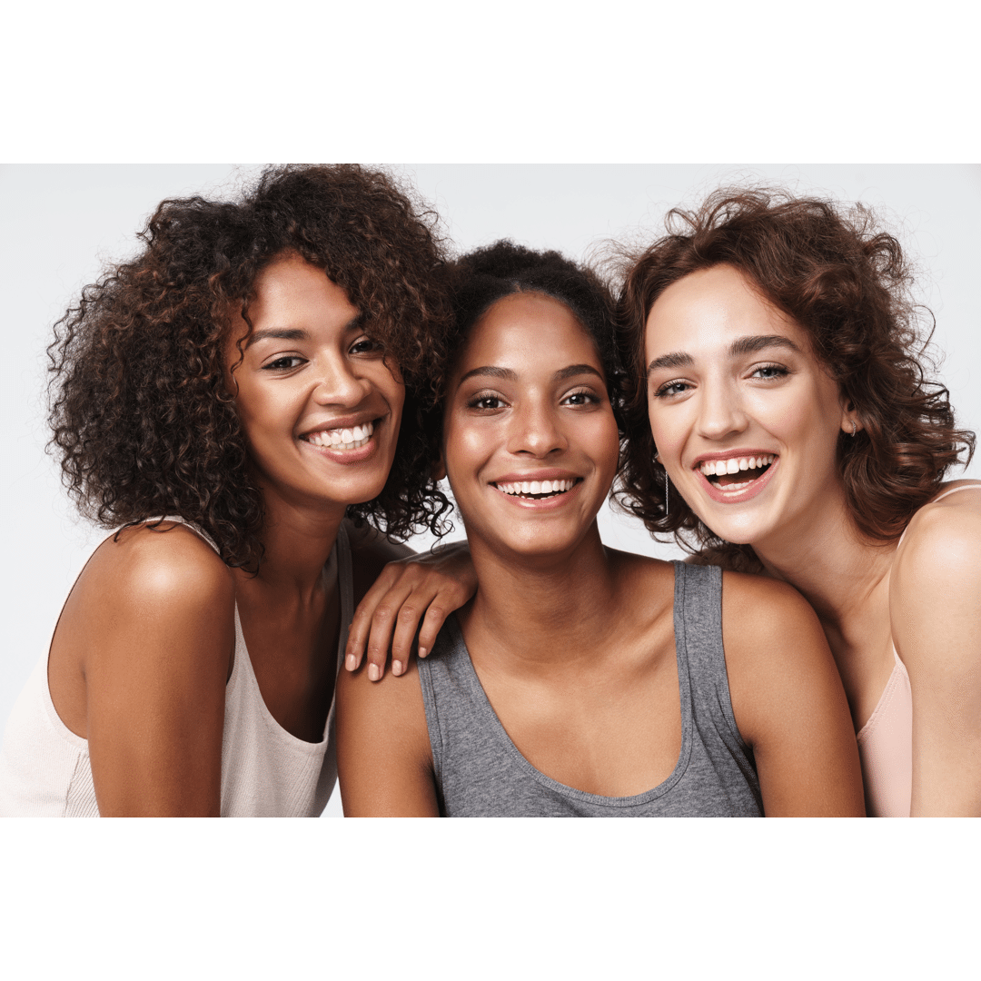 Three women smiling together and hugging