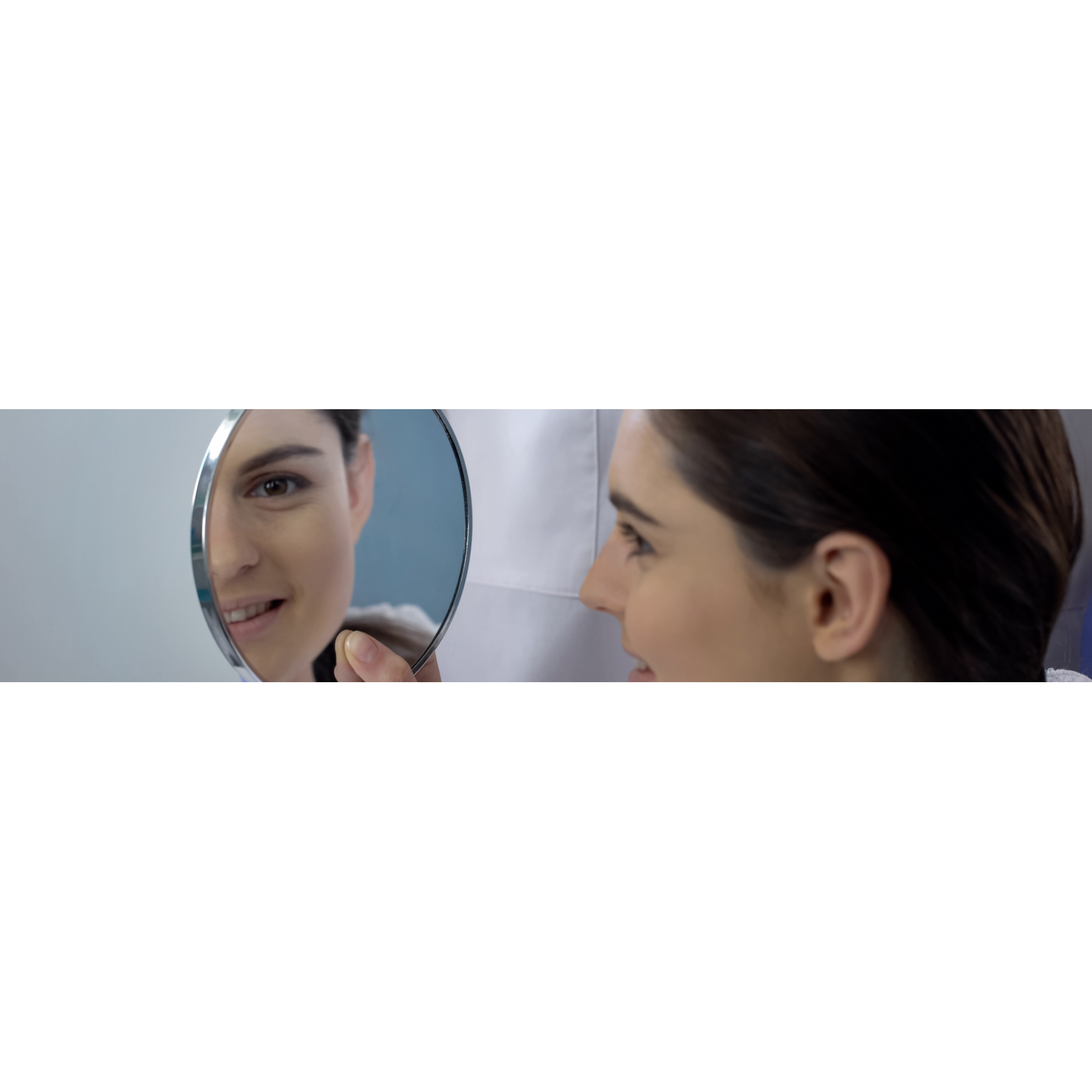 Woman looking in the mirror after undergoing rhinoplasty surgery.