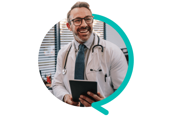 Doctor holds a notepad and smiles in the direction of the camera